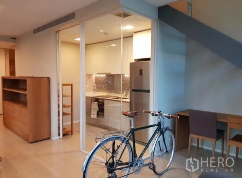 Condominium for rent or sale in Watthana, Bangkok - Fully fitted kitchen with built-in appliances and mosaic backsplash behind a sliding glass door.