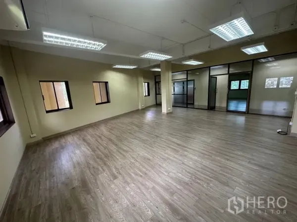 สำนักงาน ให้เช่าในChatuchak, Bangkok - ออฟฟิศแปลนโล่ง พื้นลายไม้ โคมไฟฟลูออเรสเซนต์ตะแกรง หน้าต่างหลายบาน และประตูกระจกกั้นห้อง