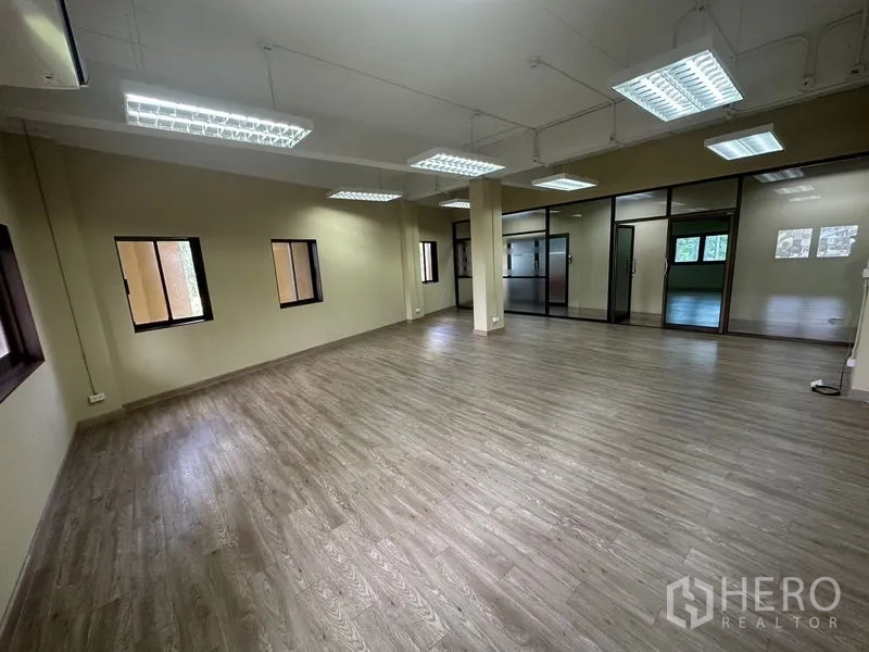สำนักงาน ให้เช่าในChatuchak, Bangkok - ออฟฟิศแปลนโล่ง พื้นลายไม้ โคมไฟฟลูออเรสเซนต์ตะแกรง หน้าต่างหลายบาน และประตูกระจกกั้นห้อง