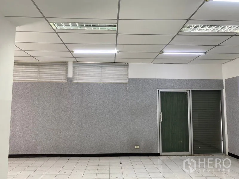 Warehouse for rent in Chatuchak, Bangkok - Office wall with windows, blinds, and sliding glass doors.
