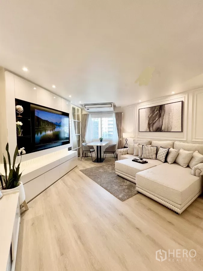 公寓 出售在Yan Nawa, Bangkok - 客厅设嵌入式电视墙、窗边餐桌和转角沙发。