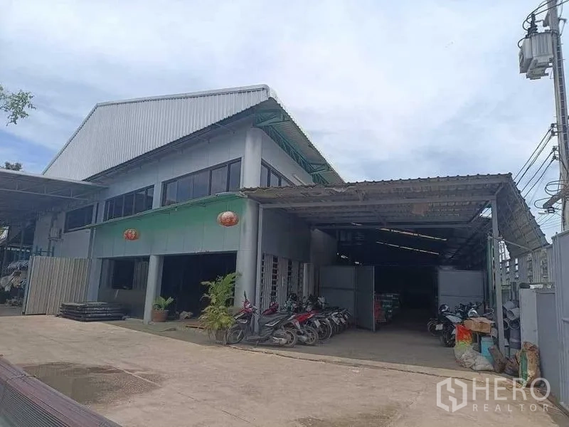 คลังสินค้า ขายในSamut Sakhon - อาคารโกดังสองชั้นหลังคาเมทัลชีท มีโถงจัดเก็บและชายคาสำหรับขนถ่ายสินค้า พร้อมที่จอดด้านหน้า