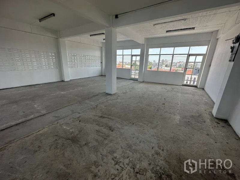 Home Office for rent in Phra Khanong, Bangkok - Unfinished room with concrete floor, breeze-block ventilation wall and wide windows.