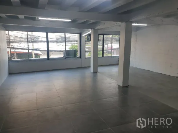 零售空间 出租在Khlong Toei, Bangkok - 宽敞零售楼层，整面大窗临街视野，外露梁顶与瓷砖地面。