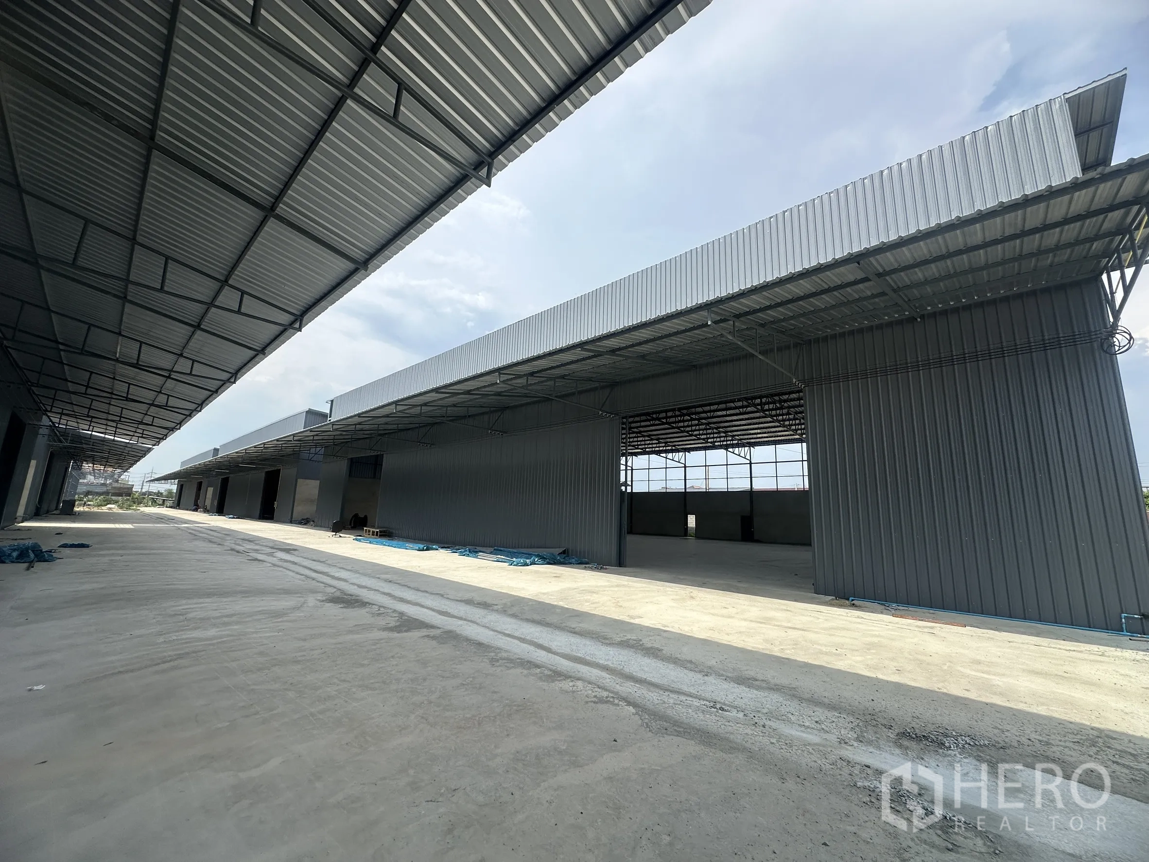 Warehouse for rent in Lam Luk Ka, Pathum Thani - Covered lane between warehouse buildings providing truck-friendly access.