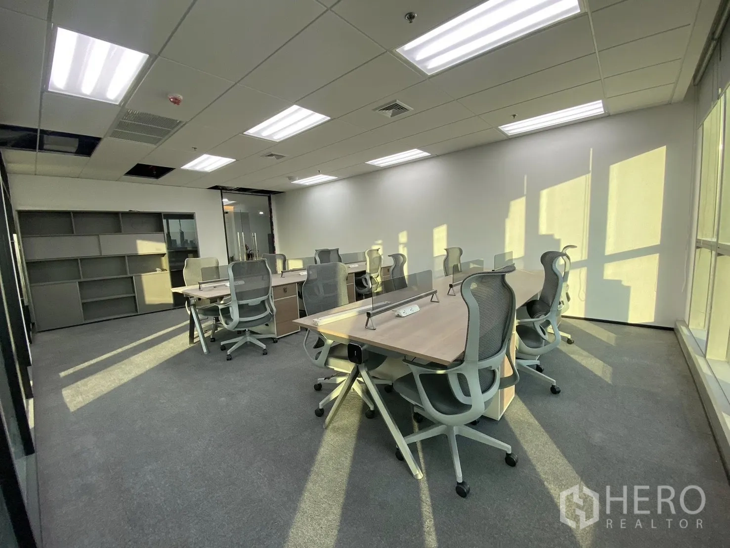 สำนักงาน for rent in Huai Khwang, Bangkok - โซนทำงานแบบโอเพ่นสเปซ มีโต๊ะและเก้าอี้ครบ พื้นพรม รับแสงธรรมชาติ