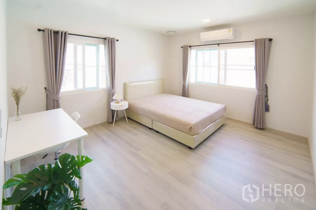 Detached House for rent in Bang Phli, Samut Prakan - Large airy bedroom with bed, desk and multiple windows.