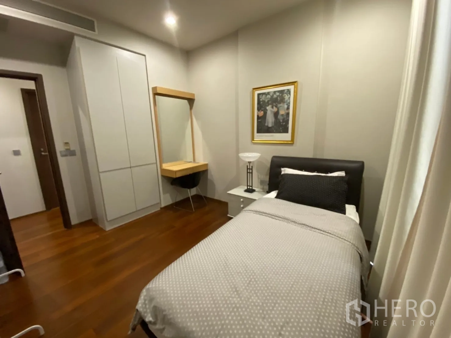 คอนโด ให้เช่าในWatthana, Bangkok - ห้องนอนที่สองแสดงตู้เสื้อผ้าบิลท์อินและโต๊ะเครื่องแป้งพร้อมเก้าอี้บนพื้นไม้