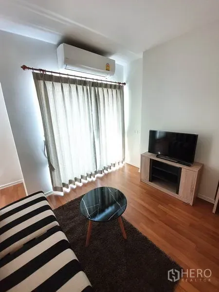 คอนโด ขายในChatuchak, Bangkok - มุมสว่างใกล้ประตูระเบียง มีแอร์ ทีวี และโต๊ะกาแฟทรงกลม