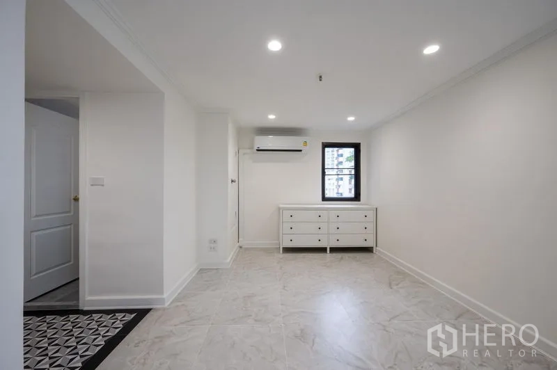 Condominium for sale in Watthana, Bangkok - Bright multipurpose room with air-conditioning, dresser and a city-view window.