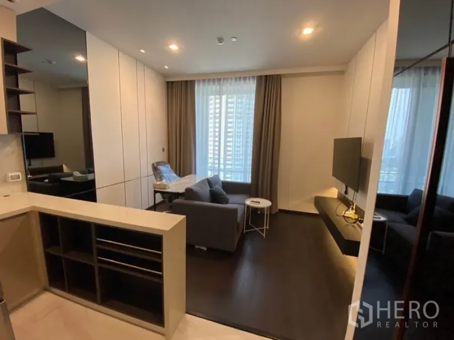 Condominium for rent in Watthana, Bangkok - Modern living room with sofa, wall-mounted TV and floor-to-ceiling window in a Thonglor-area condo.