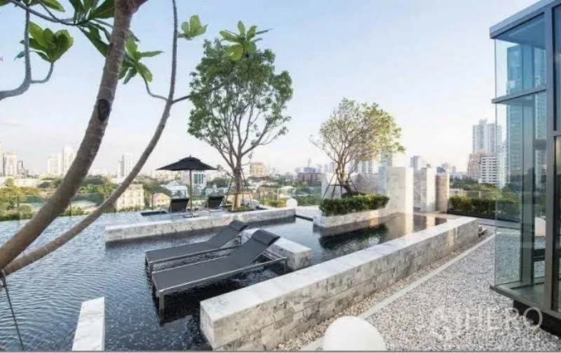 Condominium for rent in Watthana, Bangkok - Rooftop pool with sun loungers, landscaped trees, and panoramic city views.