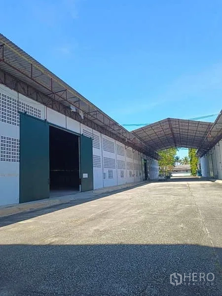 货栈 出租在Mueang Rayong, Rayong - 一排仓库装卸口，雨棚覆盖宽阔通道。