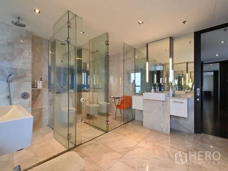 公寓 出租在Sathon, Bangkok - 宽敞浴室，大理石瓷砖、镜面双台盆，独立玻璃淋浴与马桶间。