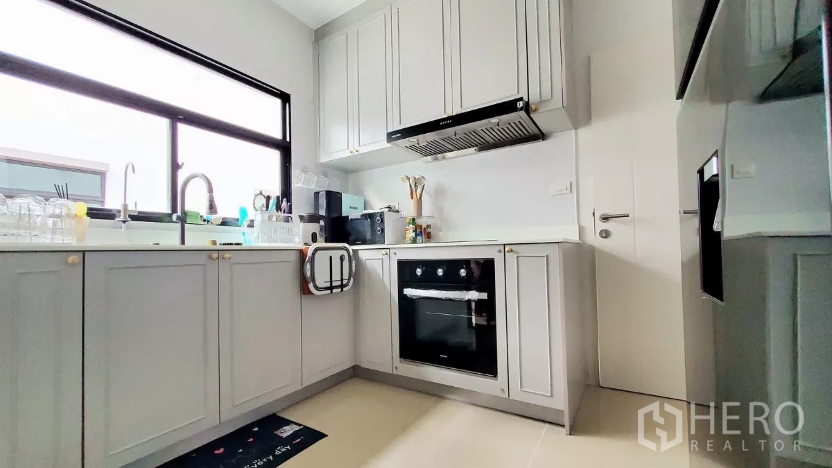 บ้าน ให้เช่าในLat Krabang, Bangkok - ครัวบิวท์อินครบครัน มีเตาอบ เครื่องดูดควัน และหน้าต่างยาวเหนือซิงก์