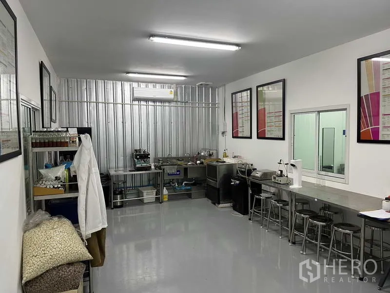 Factory for rent in Khlong Luang, Pathum Thani - Quality control lab with stainless counters, sinks, equipment and framed charts.