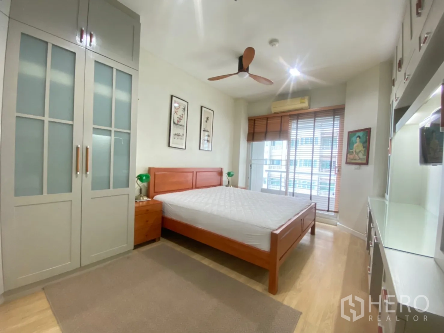 คอนโด ให้เช่าในBang Kapi, Bangkok - ห้องนอนสว่าง เตียงไม้ ตู้เสื้อผ้าบิลท์อิน พัดลมเพดาน และทางออกสู่ระเบียง