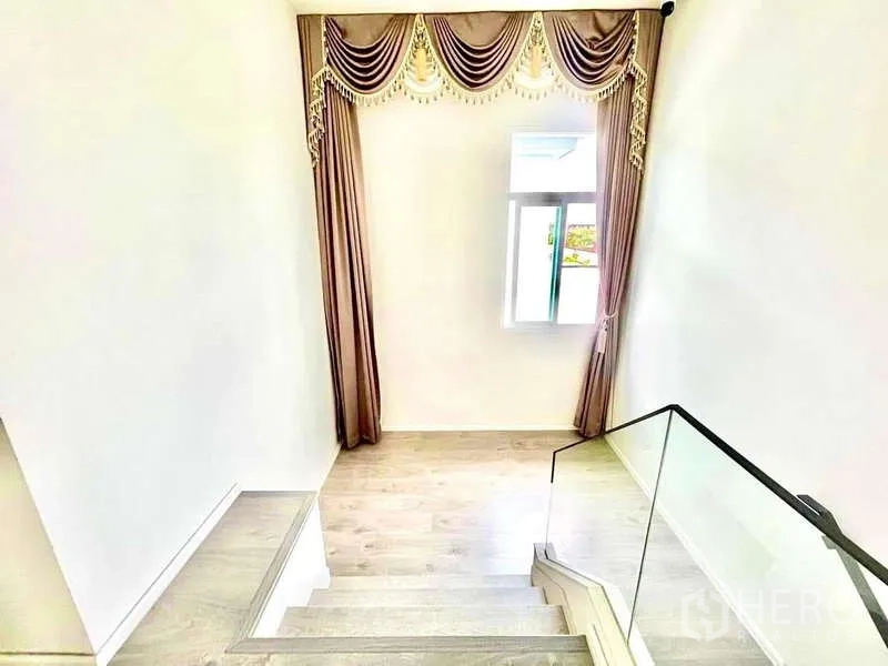 บ้าน ให้เช่าในPrawet, Bangkok - ชานบันไดมีผ้าม่านตกแต่ง หน้าต่าง และพื้นไม้โทนอ่อน.