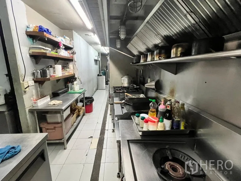 零售空间 出租在Watthana, Bangkok - 商用餐厅厨房，不锈钢操作台、抽油烟系统、燃气炉灶与置物架。