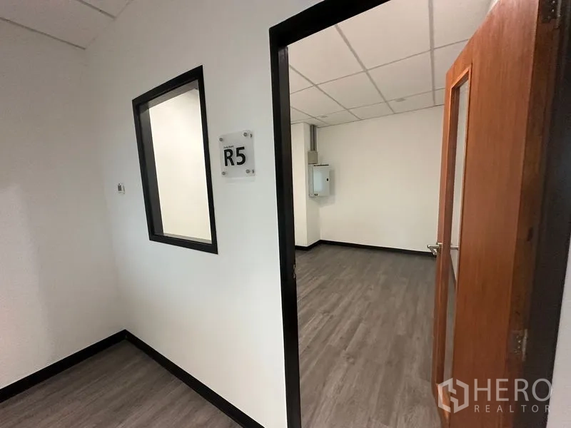 办公空间 出租在Khlong Toei, Bangkok - 标注R5的房间门口，内有设备箱与PVC木纹地板