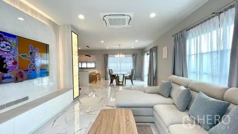 บ้านเดี่ยว for rent or sale in Bang Phli, Samut Prakan - ห้องนั่งเล่นโซฟาเข้ามุม ผนังทีวี และแปลนเปิดโล่ง