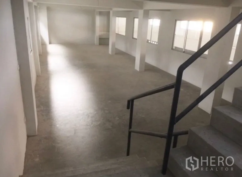 货栈 出租或出售在Bang Phli, Samut Prakan - 从楼梯眺望的混凝土夹层，沿墙布置长窗。