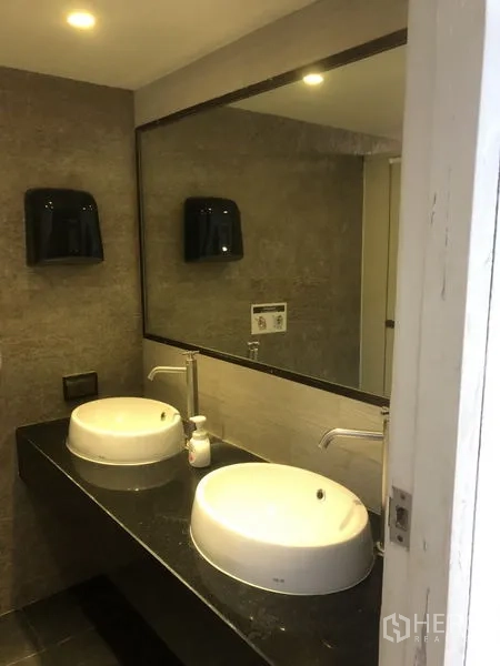 สำนักงาน ให้เช่า - ห้องน้ำสมัยใหม่ อ่างล้างหน้าทรงกลมคู่ กระจกบานใหญ่ และผนังโทนเทา
