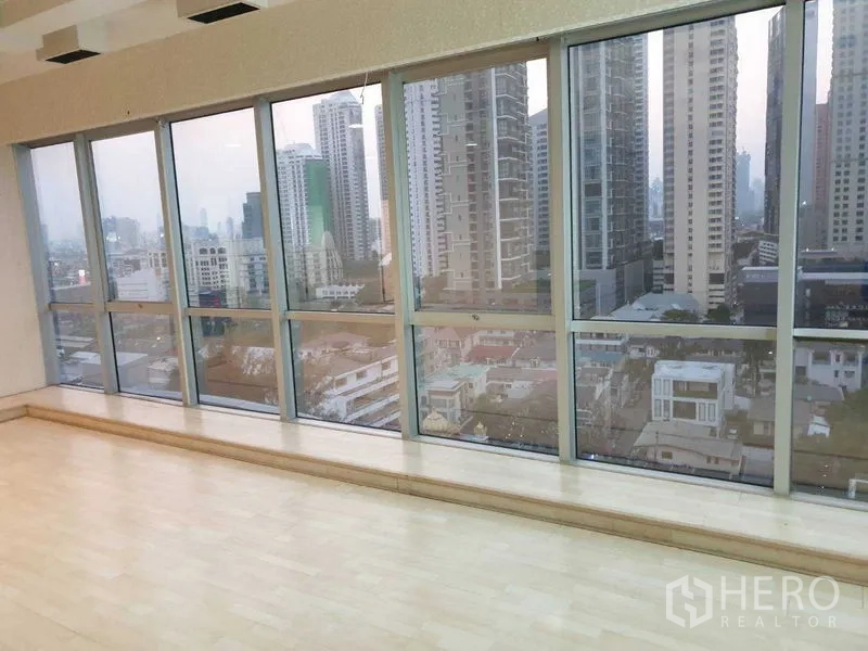 Office Space for rent - Bright office with floor-to-ceiling windows, light wood floors and Bangkok skyline view.