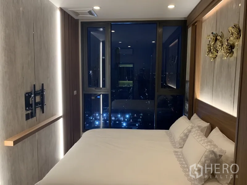 คอนโด ขายในPhra Khanong, Bangkok - ห้องนอนใหญ่เตียงคิง พร้อมหน้าต่างมุมกว้างเห็นวิวเมืองกลางคืน