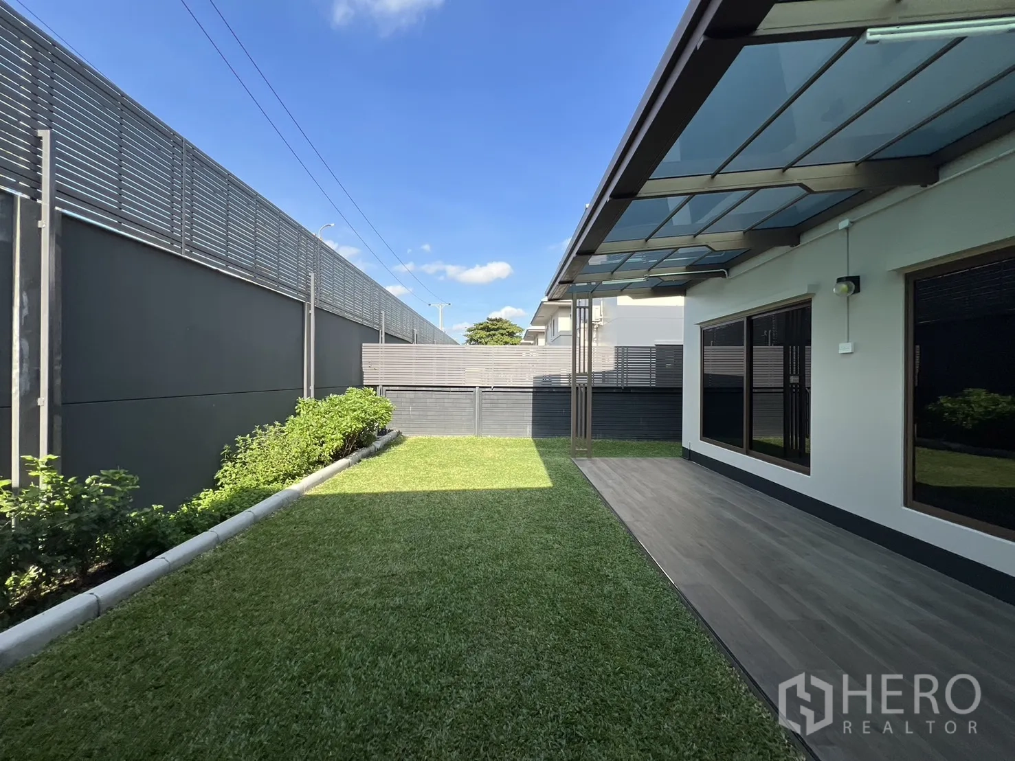 Detached House for rent or sale in Bang Kapi, Bangkok - Long lawn along the side of the house with canopy and privacy fence