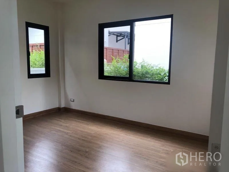 Detached House for sale in Bang Phli, Samut Prakan - Corner bedroom with two windows and wood laminate flooring