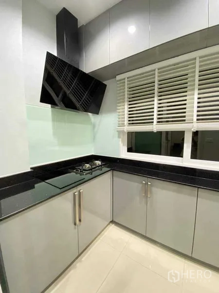 独立式住宅 出租在Bang Khen, Bangkok - 现代厨房，燃气灶、抽油烟机、吊柜和百叶窗。
