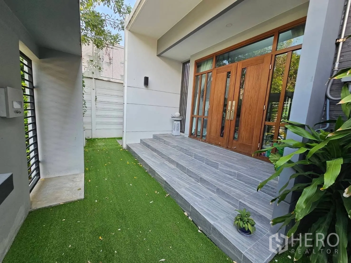 Detached House for rent or sale in Wang Thonglang, Bangkok - Entrance perspective showing turf garden and tiled steps to wooden doors.