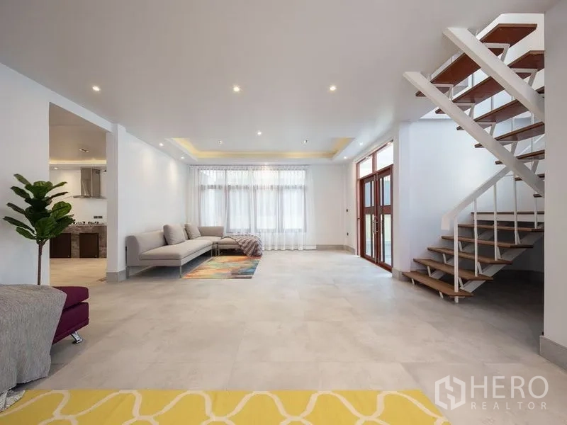 独立式住宅 出售在Chatuchak, Bangkok - 大客厅配开放式楼梯、筒灯与瓷砖地面。