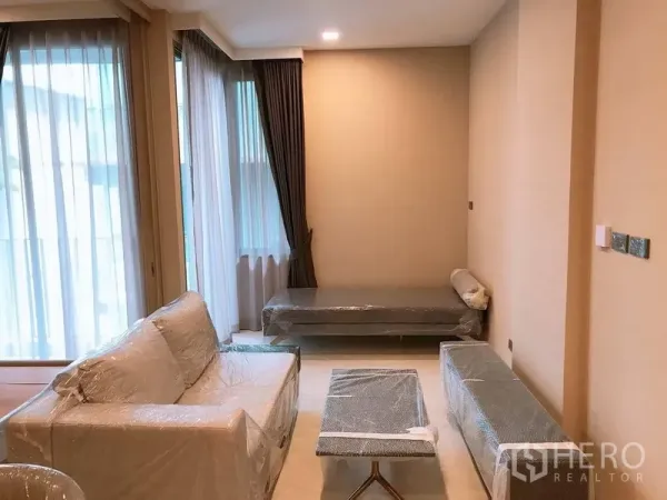 公寓 出租在Watthana, Bangkok - 采光充足的客厅，落地窗、沙发、贵妃榻与遮光窗帘。