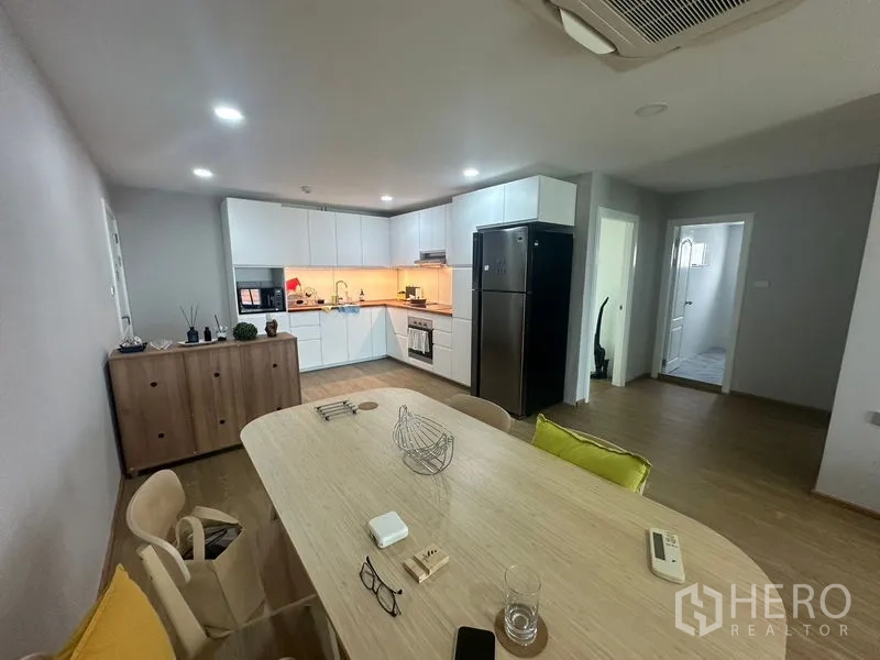 Condominium for rent - Dining area beside a modern kitchen with integrated appliances and cabinetry.