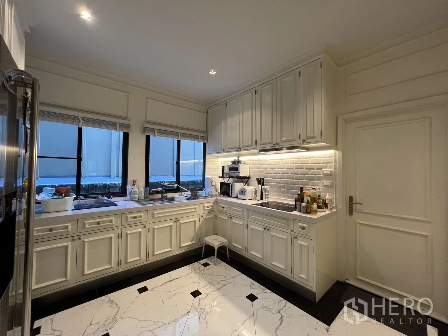 Detached House for rent in Suan Luang, Bangkok - Kitchen counter with white cabinets, subway tile backsplash and sink.