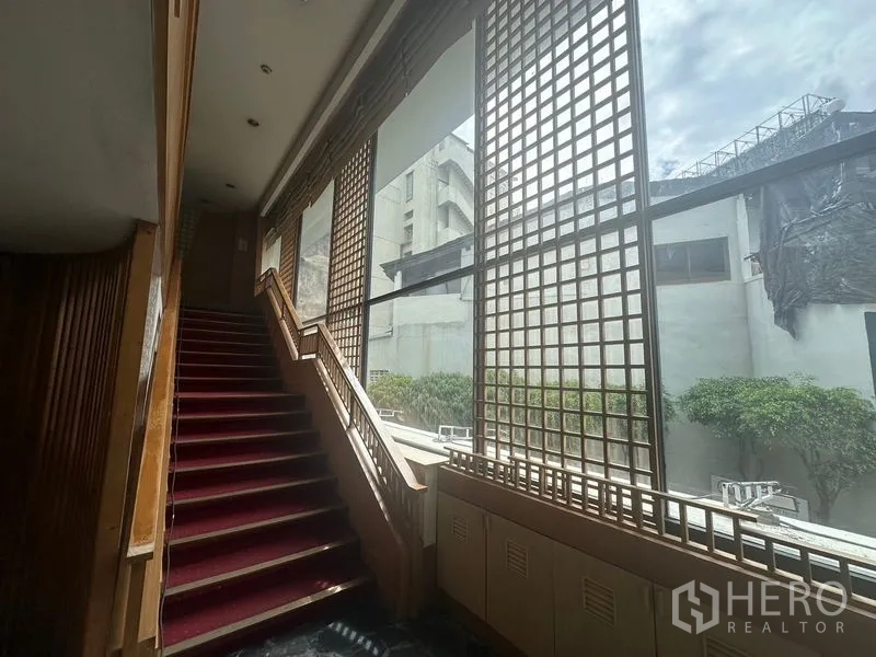 零售空间 出租在Bang Rak, Bangkok - 红毯楼梯，旁有高耸格栅窗，城市景观