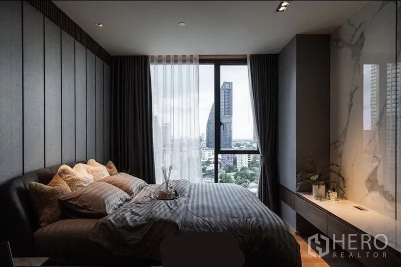 公寓 出租在Khlong Toei, Bangkok - 卧室设大窗城市景观，配大理石装饰墙与收纳柜。