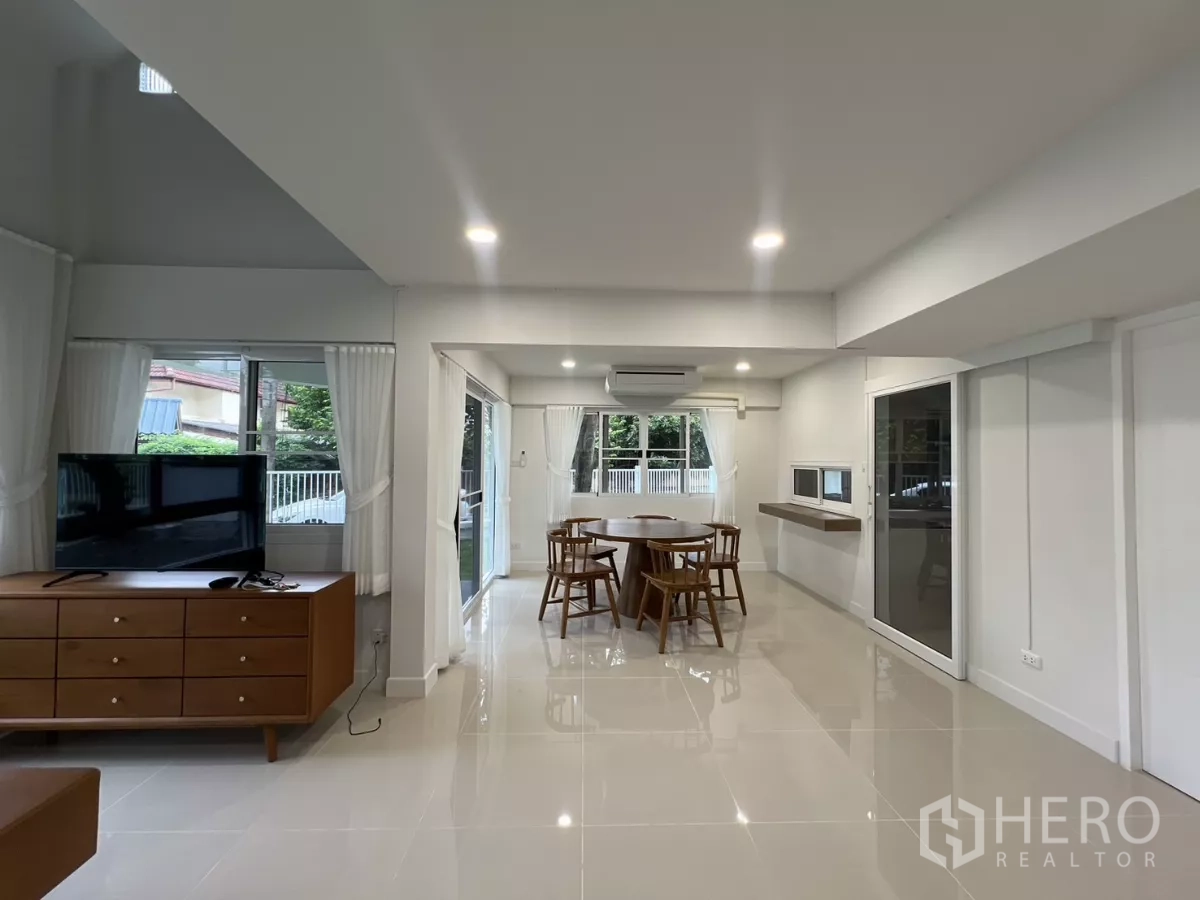 Detached House for rent in Saphan Sung, Bangkok - Living and dining area with white curtains, recessed lights and garden outlook.