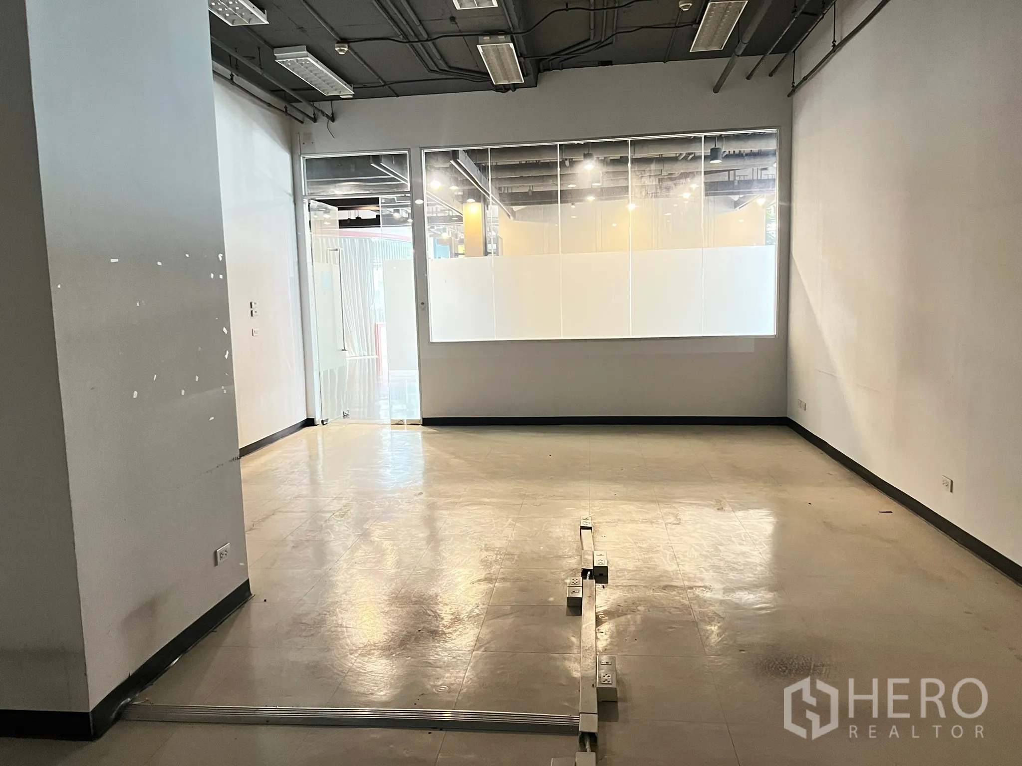 零售空间 出租 - 49㎡开放式店内空间，玻璃门面、光亮地面与外露顶灯。