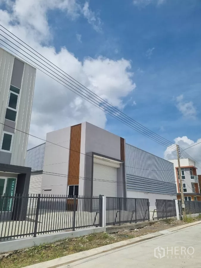 คลังสินค้า ขายในLam Luk Ka, Pathum Thani - ภาพใกล้โกดังประตูม้วนและรั้วด้านหน้า