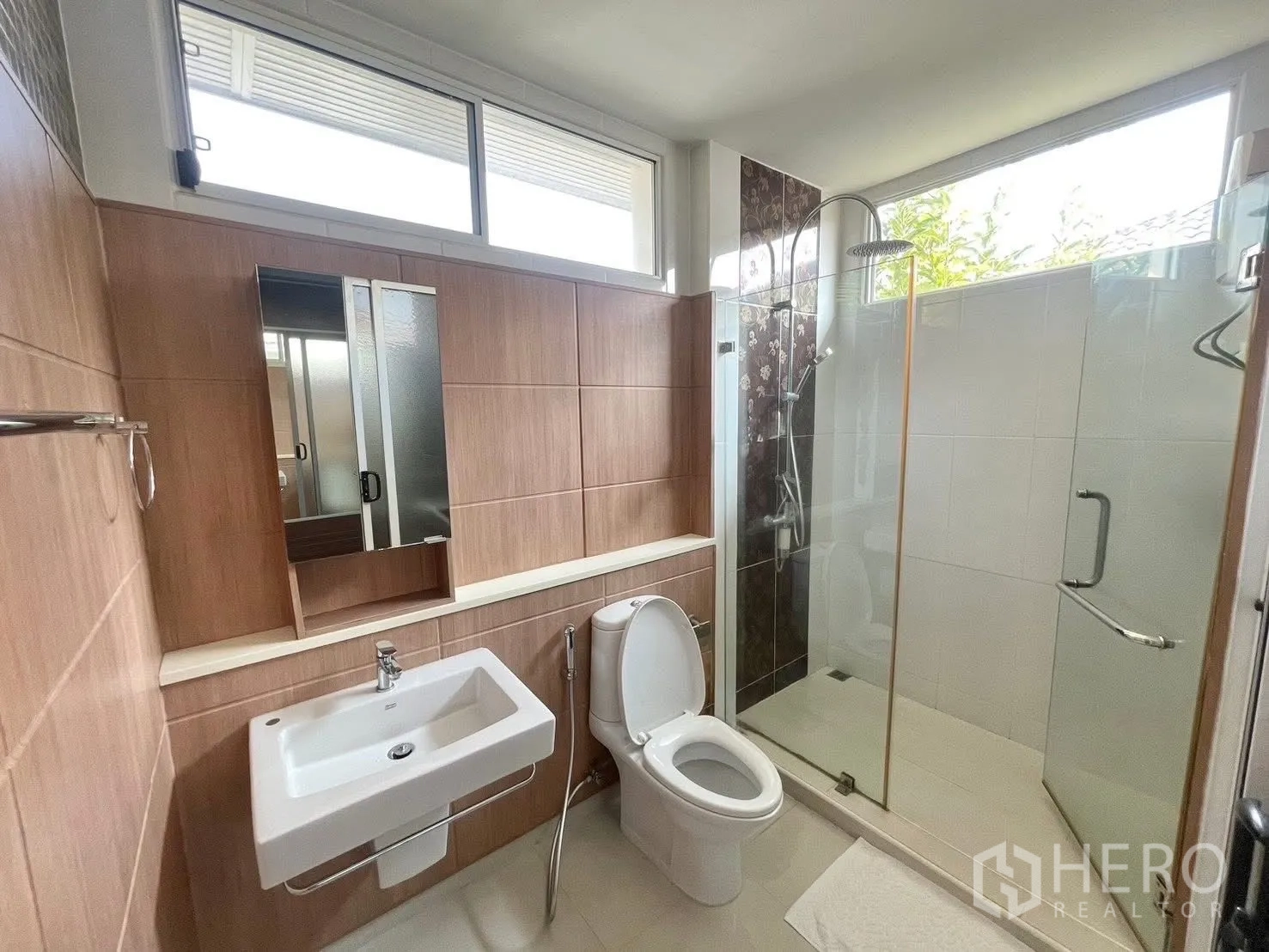 独栋房屋 for rent in Prawet, Bangkok - 浴室带玻璃淋浴间与镜柜，木纹墙面。