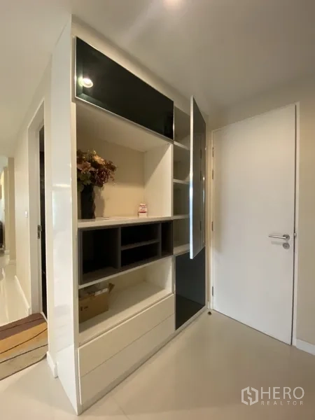 Condominium for rent in Watthana, Bangkok - Entry corridor featuring modern built-in shelving and a white interior door.