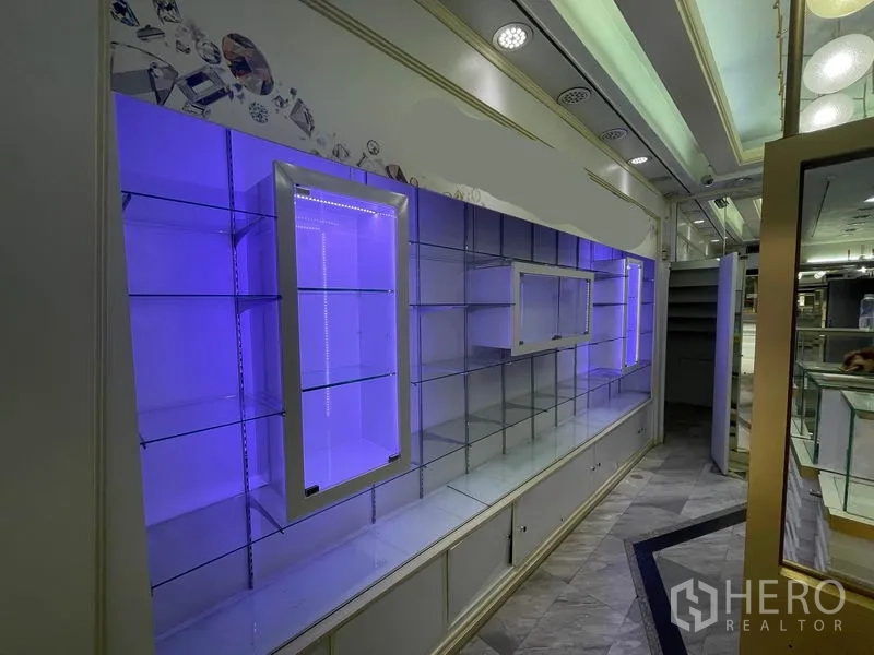 店屋 出租在Bang Rak, Bangkok - 紫色LED背光的玻璃展示墙，适合商品陈列。