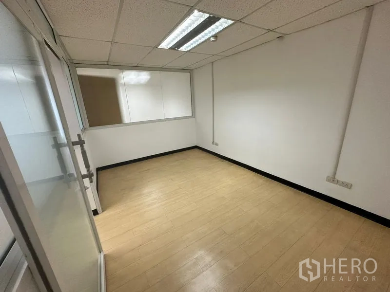 办公空间 出租 - 小型会议室，荧光灯照明和玻璃隔断门。