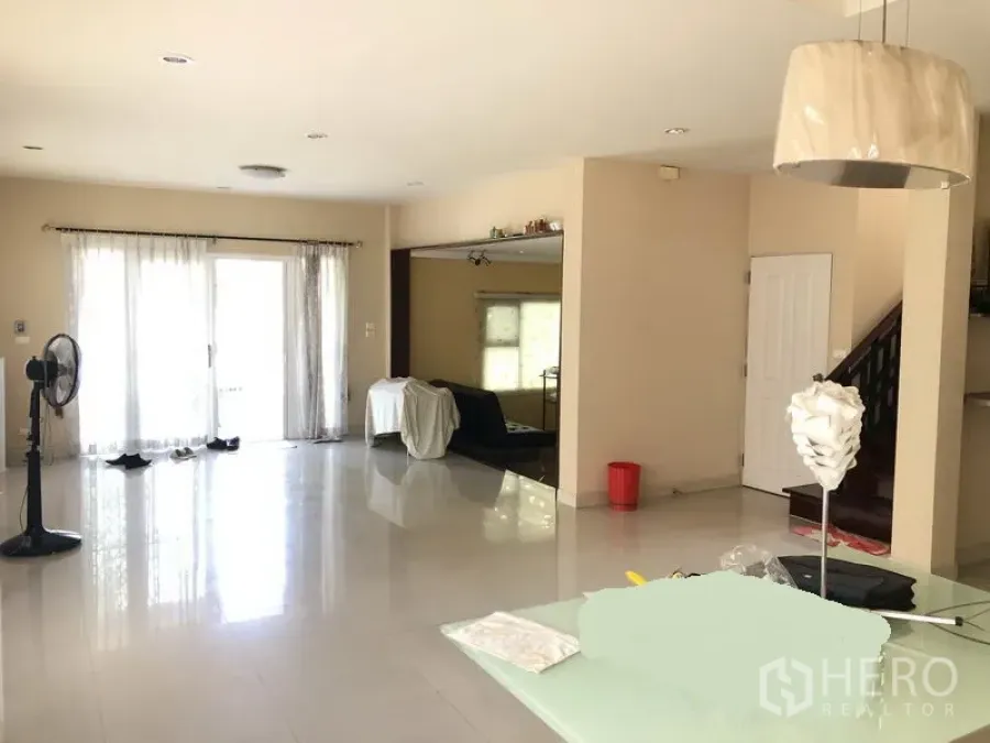 独立式住宅 出租或出售在Bang Kapi, Bangkok - 采光充足的开放式客厅，亮面地砖与窗帘，旁有楼梯。