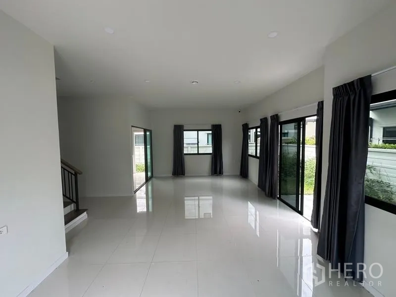 Detached House for sale in Khlong Sam Wa, Bangkok - Open-plan living room with glossy white tiles and wraparound windows