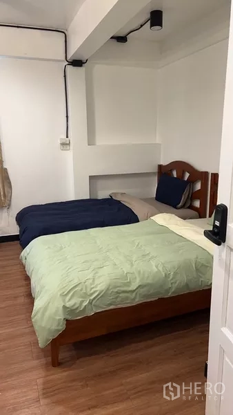 带办公室的家 出租或出售在Phra Khanong, Bangkok - 紧凑型卧室，两张单人床与木地板。