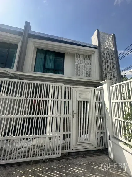 ทาวน์เฮาส์ ให้เช่าในWatthana, Bangkok - ประตูรั้วและด้านหน้าบ้านพร้อมหน้าต่างกระจกสีเขียว